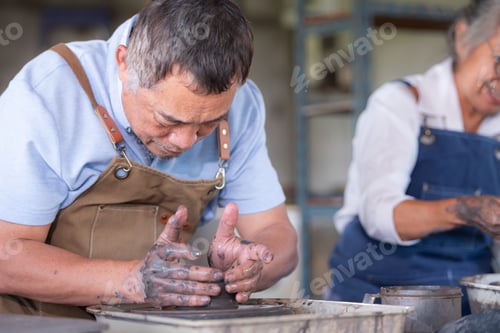 Preview: Portrait of a senior Asian couple doing activities together in the pottery workshop.