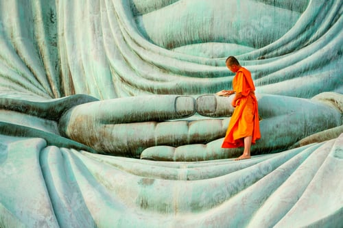 Preview: Young monk stay alone on green big buddha statue and clean in area of hands of statue