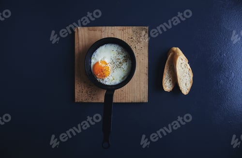 Preview: Top view tasty healthy breakfast: fried egg in small vintage pan
