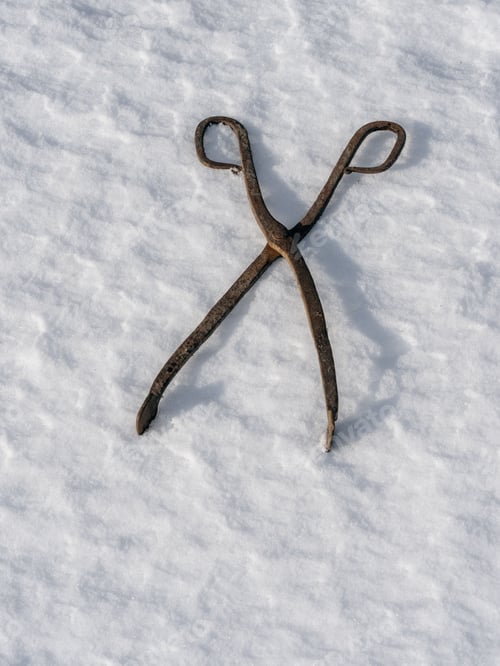 Preview: Vertical closeup of an old rusty blacksmith pliers on the white background