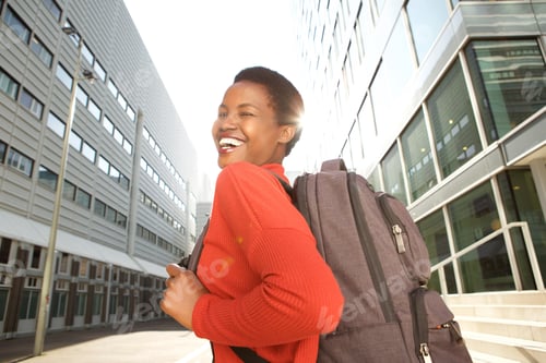 Preview: happy female student walking with bag in city
