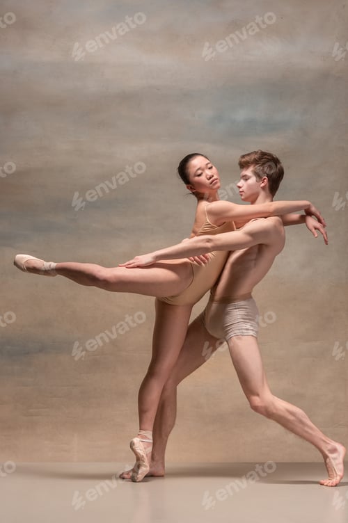 Preview: Couple of ballet dancers posing over gray background