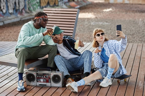 Preview: Young people hanging out outdoors with boombox