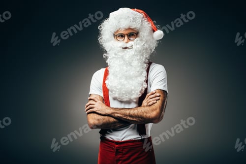 Preview: santa claus in eyeglasses standing with crossed arms isolated on grey background