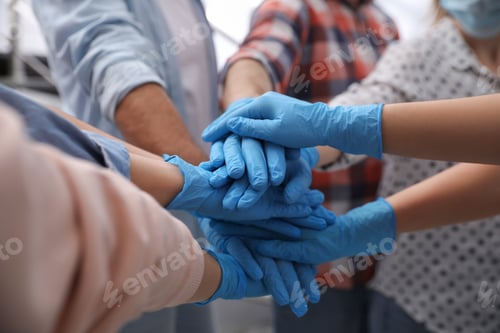 Preview: Group of people in blue medical gloves stacking hands indoors, closeup