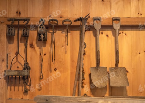Preview: Collection of farm tools and shovels hung on the wall of a traditional wooden barn in New England