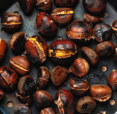 Preview: Roasted chestnuts lying on dark surface
