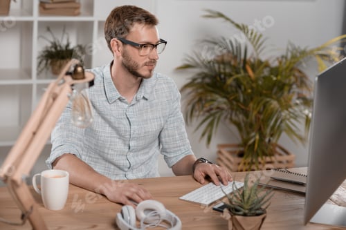 Preview: focused caucasian businessman working with computer while sitting at workspace