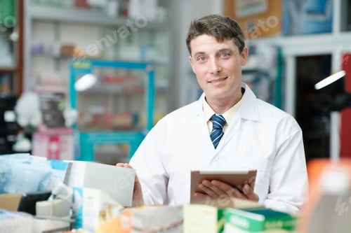 Preview: Male pharmacist checking stock inventory in pharmacy.