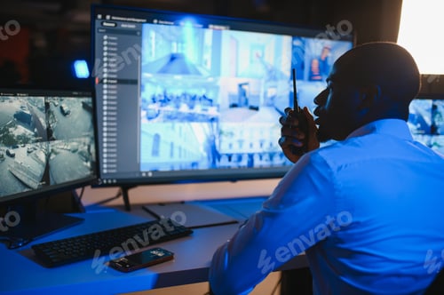 Preview: Back view of African American security operator use computer with screens