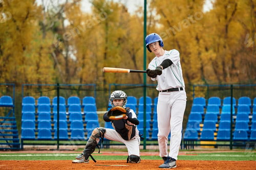 Preview: Teenage boys engage in an exciting baseball game on a sunny afternoon field