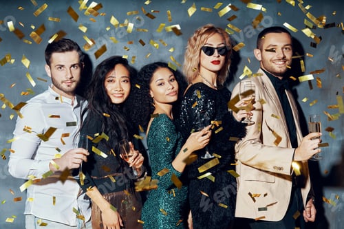 Preview: Happy young people dancing and having fun with confetti flying everywhere