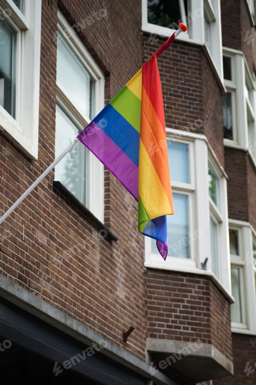 Preview: Vertical shot of the pride flag hanging from a wall