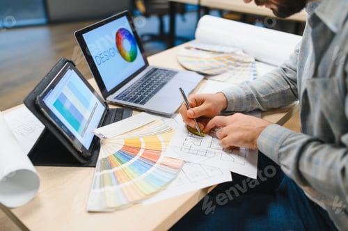Preview: Interior designer working on blueprint with color swatches