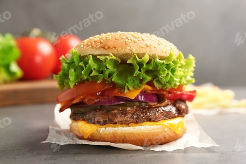 Preview: Tasty burger with bacon on grey table