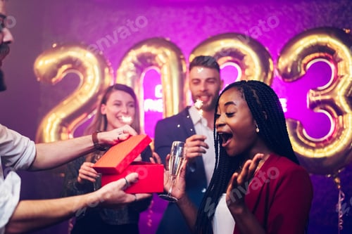 Preview: Diverse couple exchanging gifts while on the birthday party or new years eve