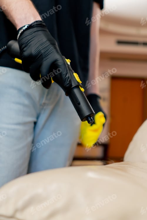 Preview: close up professional cleaning of the apartment cleaner steaming the skin on the sofa cleaning