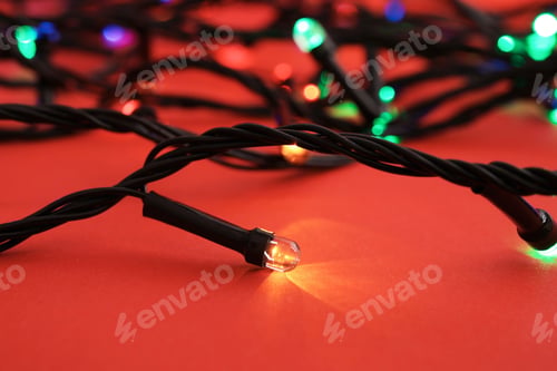 Preview: Glowing Christmas lights on color background, closeup