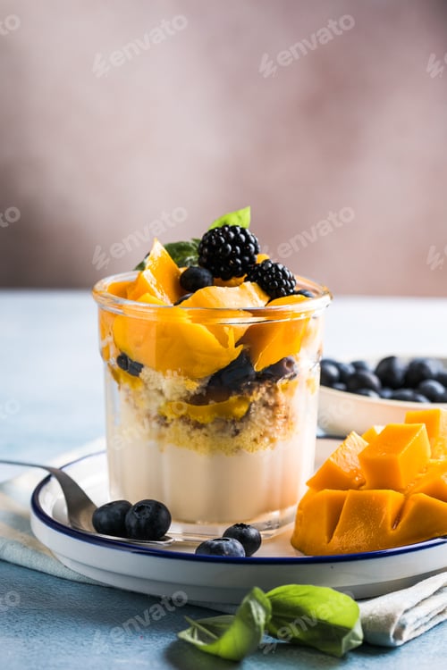 Preview: Trifle dessert with berries and cream on wooden table. Copy space