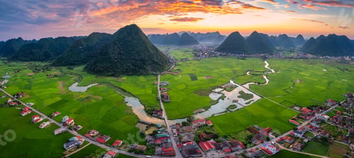 Preview: Sunset over Bac Son Valley with mountains, lush green fields, winding river and village in Vietnam