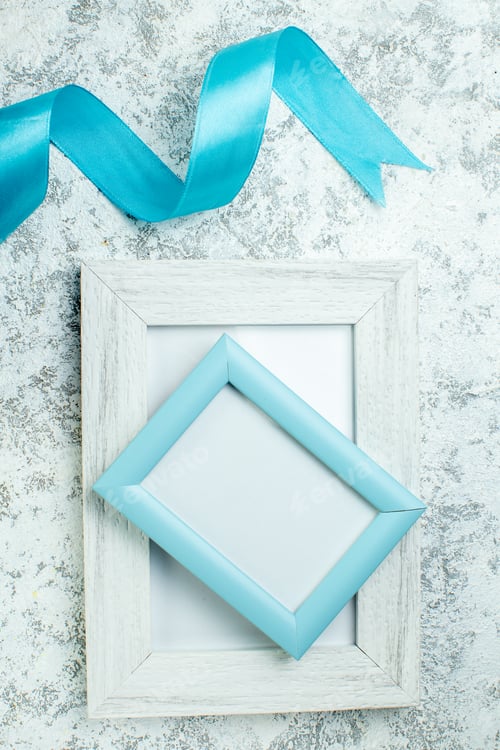 Preview: top view two blank photo frames blue ribbon on grey background
