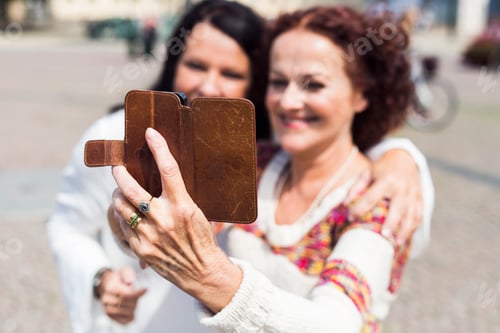 Preview: Two senior women taking selfie on city street