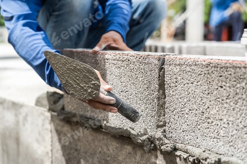 Preview: Worker Applies Mortar to Blocks at Construction Site