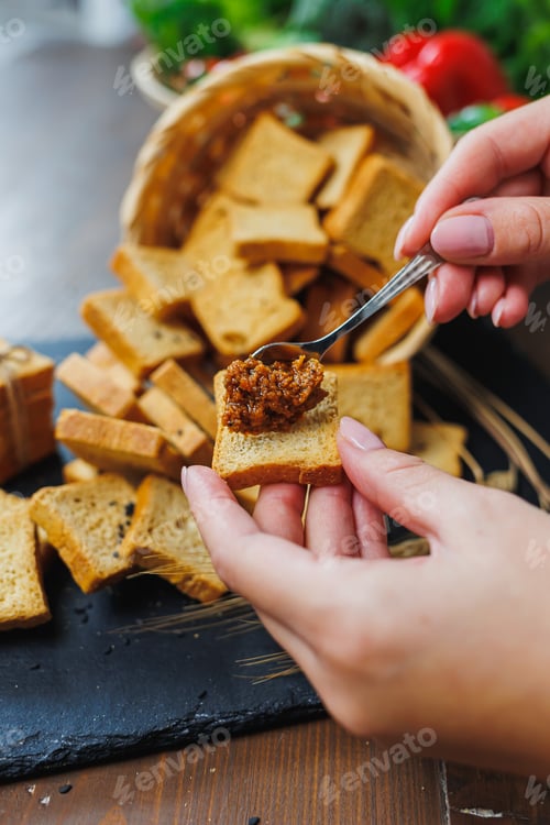 Preview: Slices of toasted bread and pate in female hands. Fresh croutons made of whole grain flour