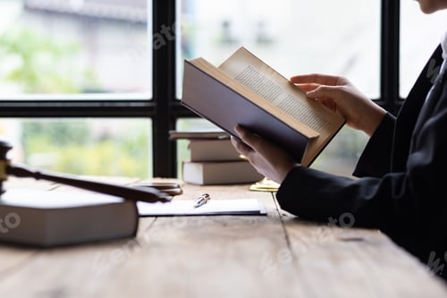 Preview: Lawyer and legal justice, Lawyer working on paperwork and reading law book in office.