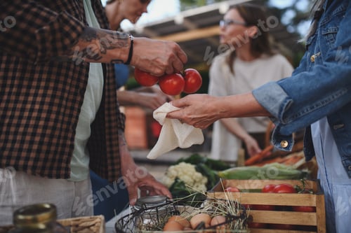 Preview: Close up of woman buying organic vegetables outdoors at local farmers market