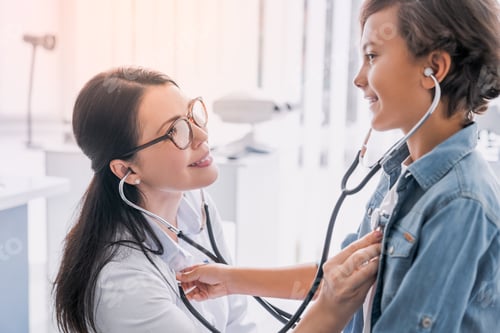 Preview: Female pediatrician examining boy in modern medical clinic