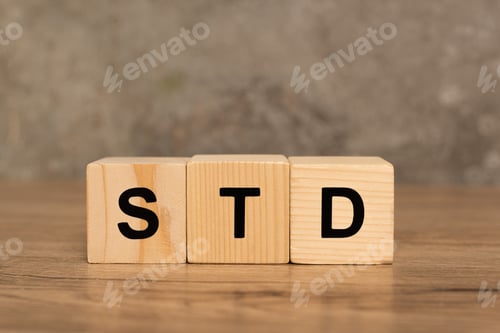 Preview: Wooden blocks with std letters on wooden table on grey background