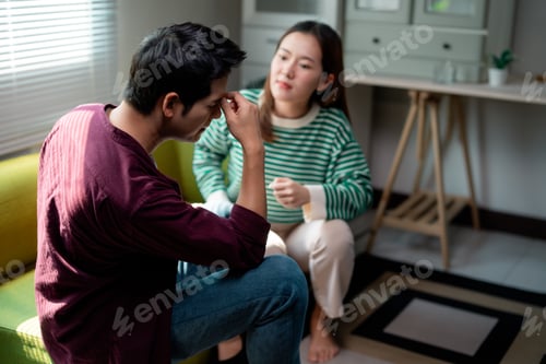 Preview: Stressed young man having headache and arguing with girlfriend at home