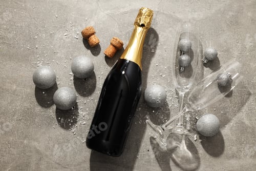 Preview: A bottle of champagne with Christmas balls on a light background