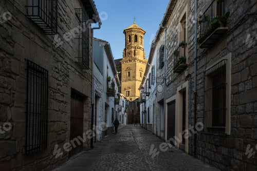 Preview: Narrow alley between residential buildings leading to a church in Baeza, Spain