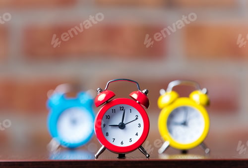 Preview: Three little red alarm clocks on table