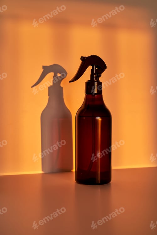 Preview: Amber spray bottle standing with warm shadow