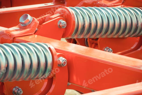 Preview: Big and hard steel silver spring as part and detail of red industrial or agricultural machine