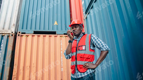 Preview: African male worker safety vest container logistics walkie talkie hard hat