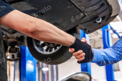 Preview: Customer and auto service mechanic shake hands. Car repair and maintenance