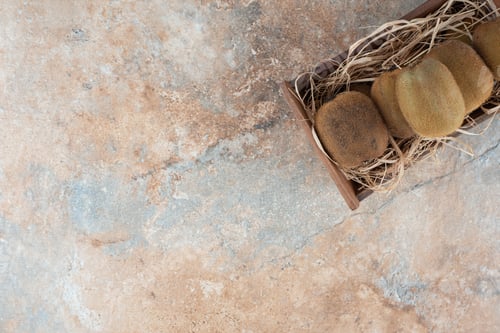 Preview: A wooden basket of fresh kiwi on marble background