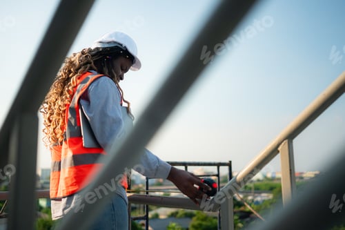 Preview: Young female engineer or architect working on construction site