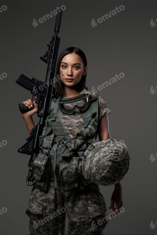Preview: Beautiful female soldier in military uniform stands holding an automatic rifle