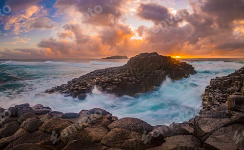 Preview: Idyllic island with rocky cliffs and crystal blue waters at sunset