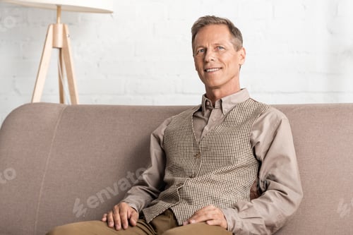 Preview: happy senior man looking at camera and sitting at home