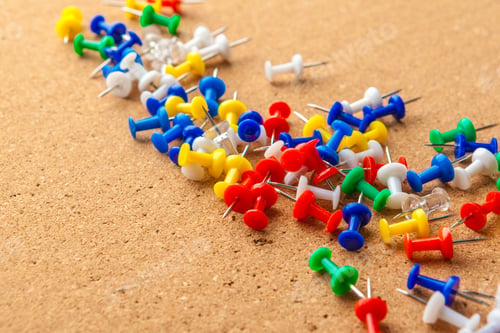 Preview: Group of colorful push pins on cork bulletin board