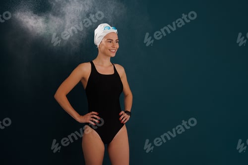 Preview: Young smiling woman swimmer against blue backdrop