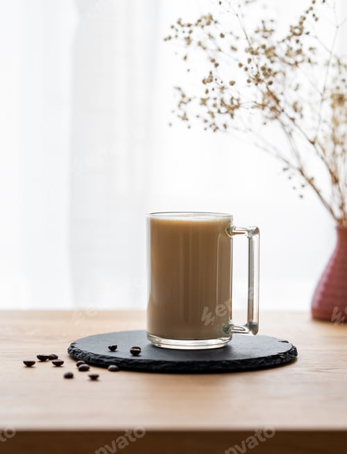 Preview: A cup of coffee with milk on a wooden table with coffee beans against the background of a window