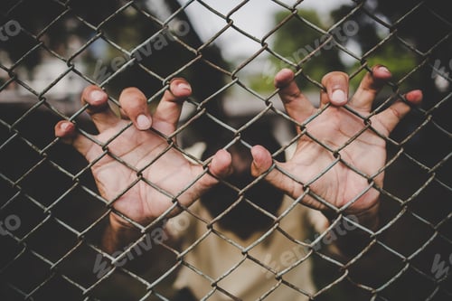 Preview: Hand with metal fence, feeling no freedom