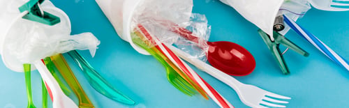 Preview: close up view of plastic cups with disposable cutlery on blue background, panoramic shot